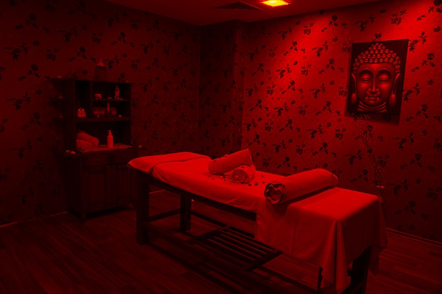 masážní lehátko červeně nasvícená místnost